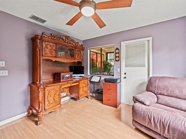 home office featuring ceiling fan, a textured ceiling, and light wood-type flooring