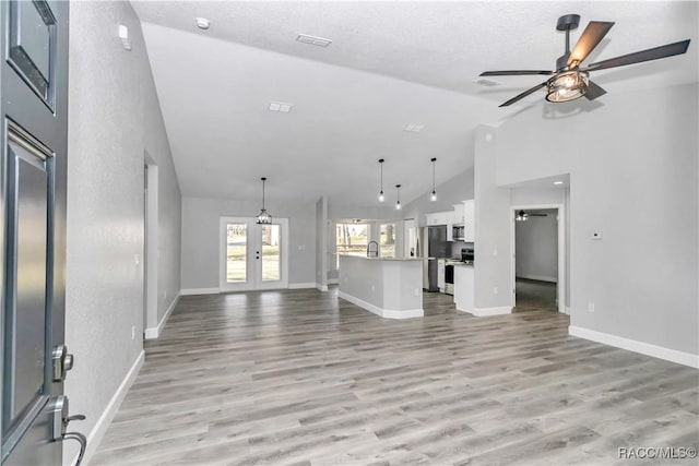 4065 SW 5th Ave, Ocala, FL 34471 - unfurnished living room with light hardwood / wood-style flooring, high vaulted ceiling, french doors, and ceiling fan