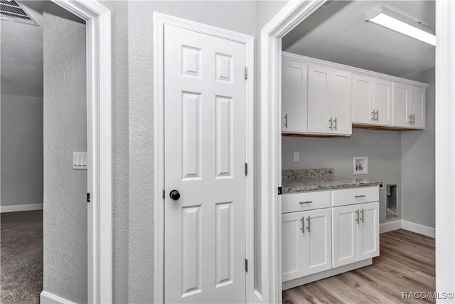 4065 SW 5th Ave, Ocala, FL 34471 - kitchen with white cabinetry, light stone countertops, and light hardwood / wood-style flooring