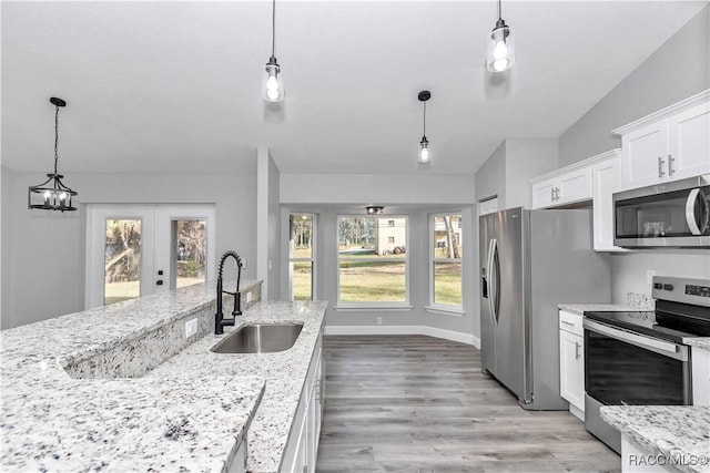 4065 SW 5th Ave, Ocala, FL 34471 - kitchen with stainless steel appliances, hanging light fixtures, sink, and white cabinets