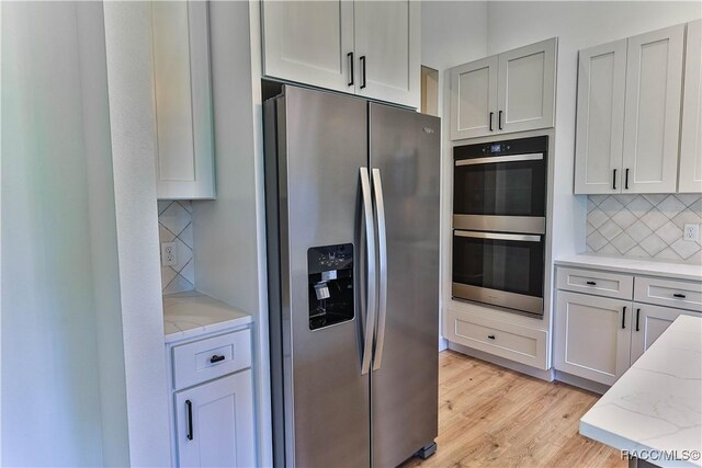 783 E Alaska Ln, Hernando, FL 34442 - kitchen with appliances with stainless steel finishes, light stone countertops, decorative backsplash, and light wood-style floors
