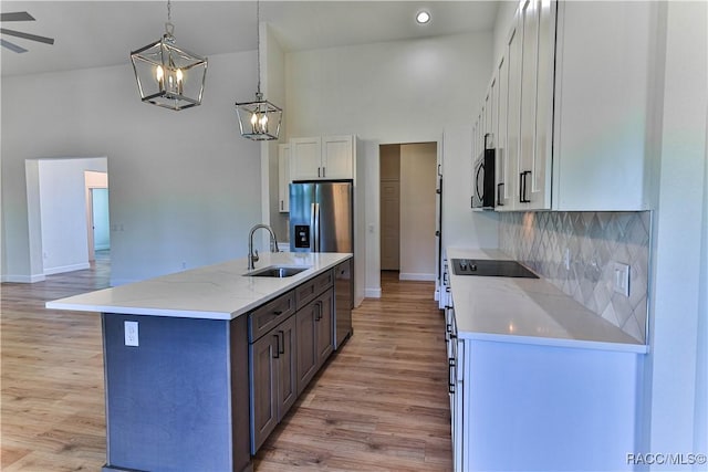 783 E Alaska Ln, Hernando, FL 34442 - kitchen featuring stainless steel appliances, white cabinetry, light wood-style flooring, a center island with sink, and a chandelier
