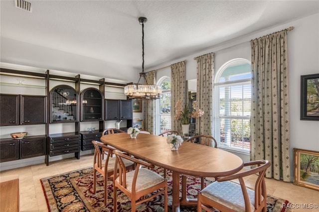 tiled dining room featuring a notable chandelier