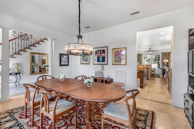 dining room featuring decorative columns, ceiling fan with notable chandelier, and light tile patterned floors