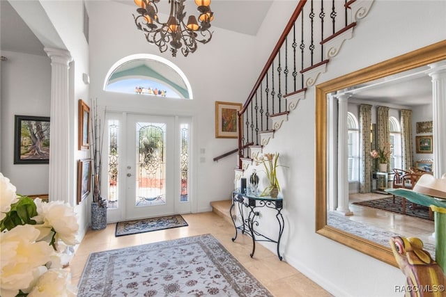 foyer featuring decorative columns, light tile patterned flooring, and a towering ceiling