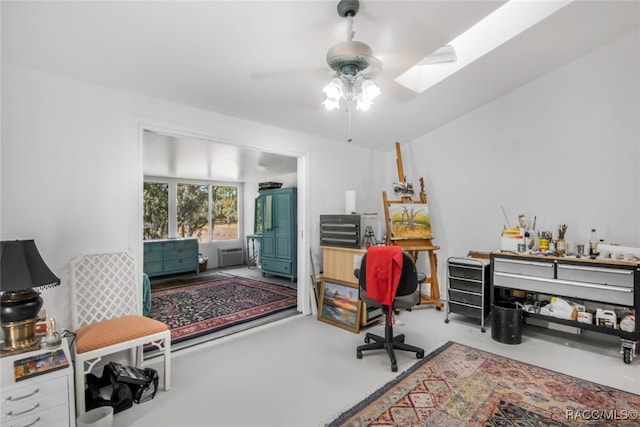 office space featuring ceiling fan, concrete floors, and vaulted ceiling with skylight