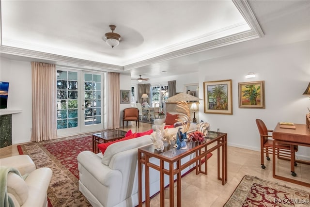 living room featuring a tray ceiling, light tile patterned floors, crown molding, and french doors