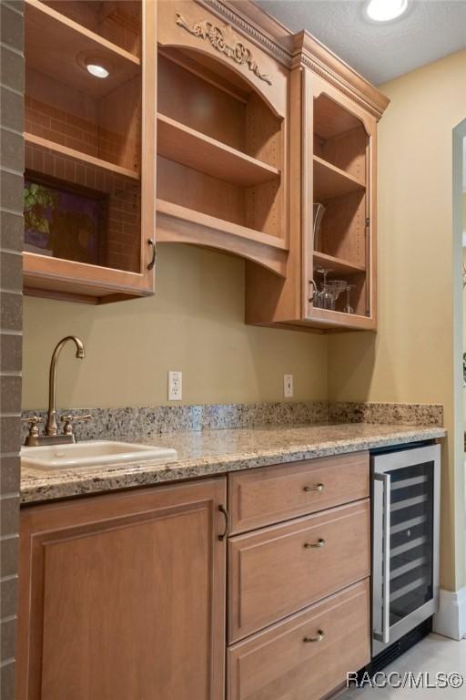 4160 W Bonanza Dr, Beverly Hills, FL 34465 - kitchen with wine cooler, a sink, open shelves, and light stone countertops