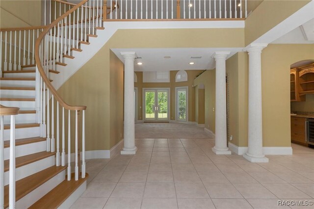4160 W Bonanza Dr, Beverly Hills, FL 34465 - foyer featuring wine cooler, tile patterned flooring, baseboards, stairway, and ornate columns