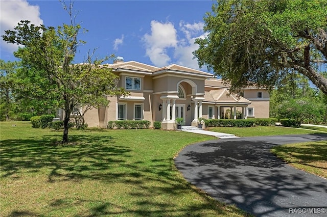4160 W Bonanza Dr, Beverly Hills, FL 34465 - mediterranean / spanish house featuring stucco siding, a front yard, a chimney, and a tiled roof