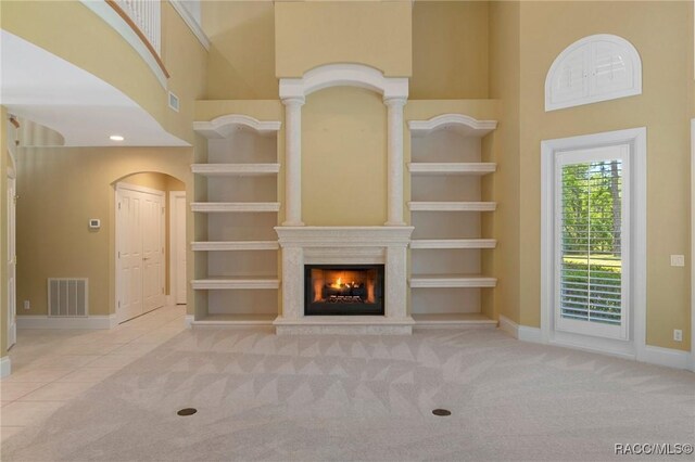 4160 W Bonanza Dr, Beverly Hills, FL 34465 - unfurnished living room featuring a towering ceiling, arched walkways, carpet floors, baseboards, and a lit fireplace
