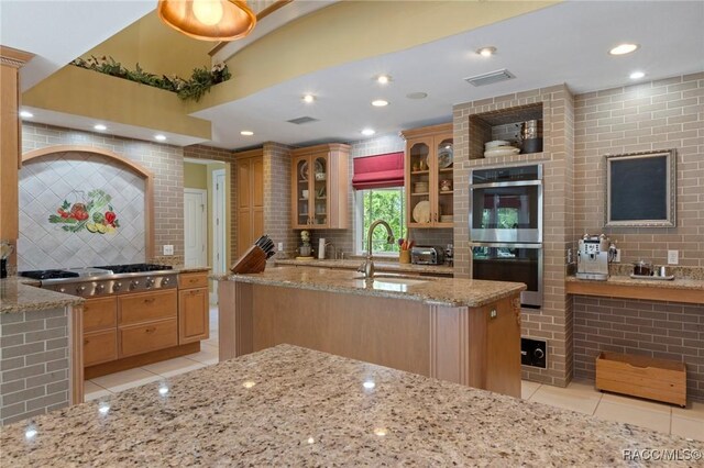 4160 W Bonanza Dr, Beverly Hills, FL 34465 - kitchen featuring appliances with stainless steel finishes, a sink, light tile patterned floors, decorative backsplash, and light stone countertops