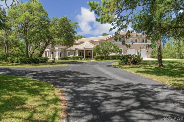 4160 W Bonanza Dr, Beverly Hills, FL 34465 - view of front of property featuring stucco siding, a garage, and a front lawn