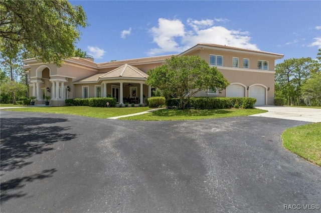 4160 W Bonanza Dr, Beverly Hills, FL 34465 - view of front of property with stucco siding, asphalt driveway, a ceiling fan, a front yard, and a garage