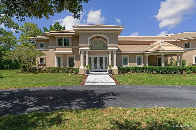 4160 W Bonanza Dr, Beverly Hills, FL 34465 - view of front of home with french doors, stucco siding, a front lawn, and a tiled roof