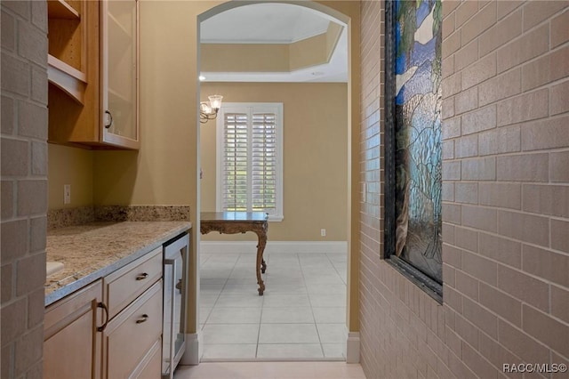 4160 W Bonanza Dr, Beverly Hills, FL 34465 - kitchen with wine cooler, light stone counters, light tile patterned floors, arched walkways, and baseboards