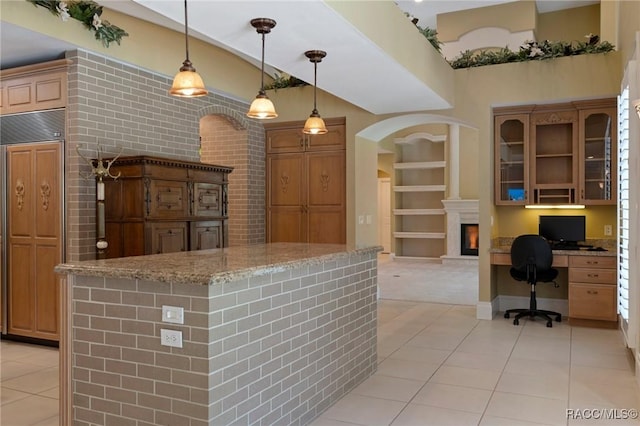 4160 W Bonanza Dr, Beverly Hills, FL 34465 - kitchen with light tile patterned floors, light stone counters, built in features, and brown cabinets