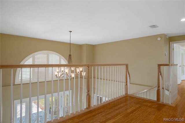 4160 W Bonanza Dr, Beverly Hills, FL 34465 - corridor featuring wood finished floors, an upstairs landing, and a chandelier