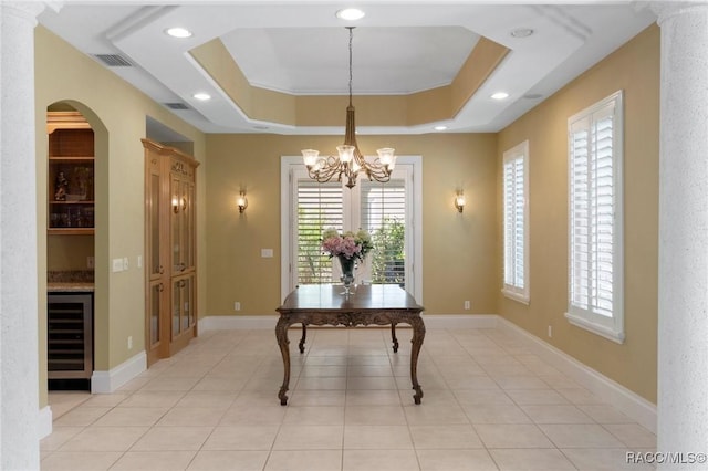 4160 W Bonanza Dr, Beverly Hills, FL 34465 - dining area featuring beverage cooler, a chandelier, arched walkways, a tray ceiling, and light tile patterned flooring