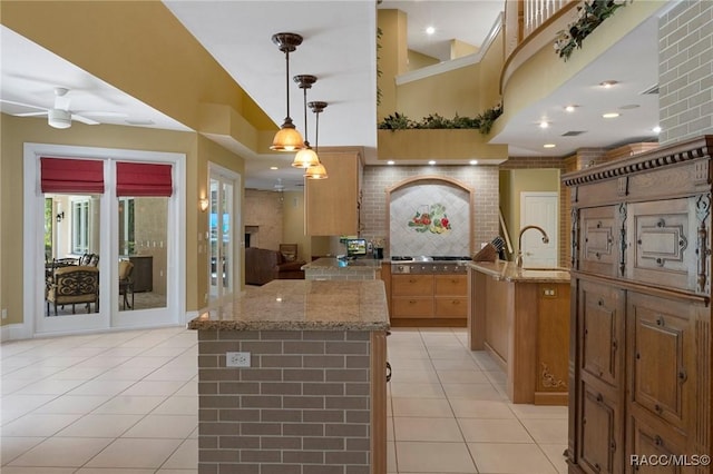 4160 W Bonanza Dr, Beverly Hills, FL 34465 - kitchen with a center island, light tile patterned floors, ceiling fan, light stone countertops, and a towering ceiling