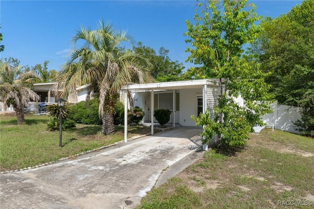 view of front of property with driveway, a carport, and stucco siding