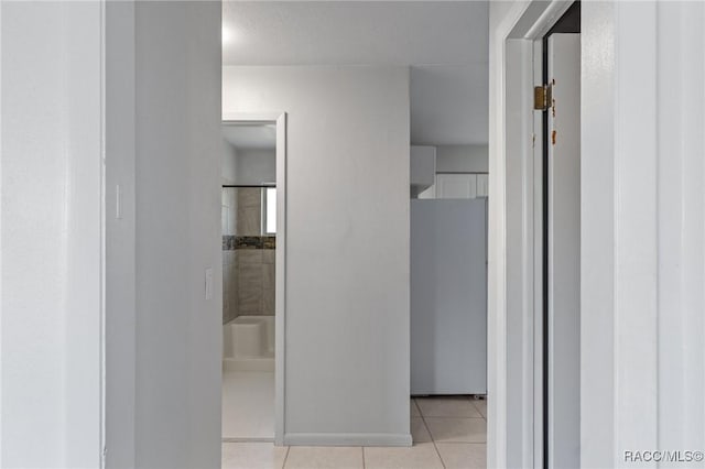 bathroom with tile patterned floors, a shower, and baseboards