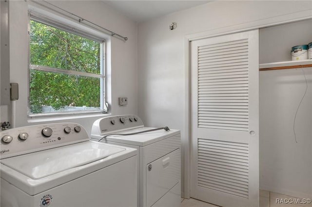washroom with washing machine and clothes dryer, plenty of natural light, and light tile patterned floors
