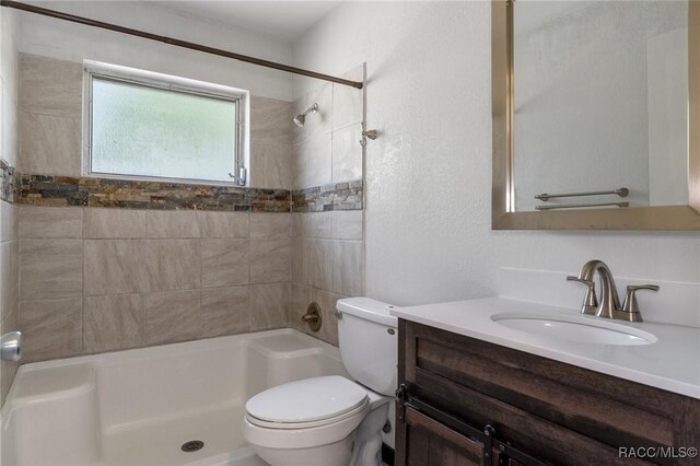 full bathroom featuring toilet, vanity, and washtub / shower combination