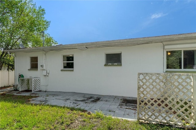rear view of house featuring a patio and stucco siding