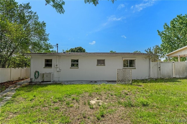 back of house featuring stucco siding and central air condition unit