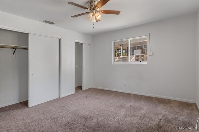 unfurnished bedroom with multiple closets, carpet, ceiling fan, and baseboards