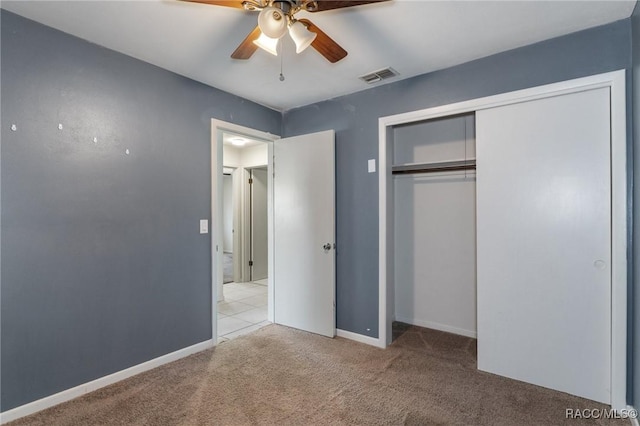 unfurnished bedroom with carpet flooring, a closet, baseboards, and ceiling fan