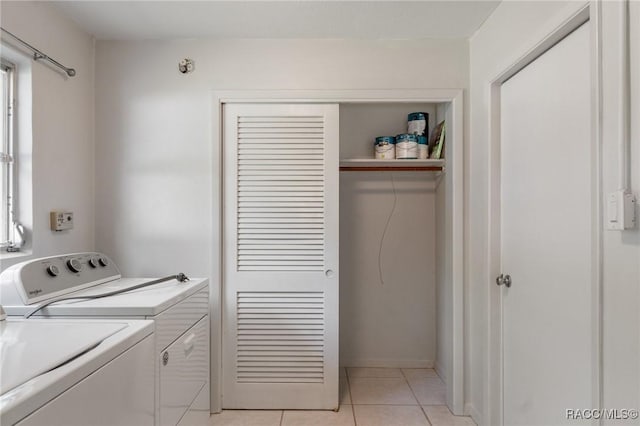 laundry area with washing machine and clothes dryer and light tile patterned floors