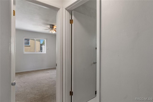 corridor featuring carpet floors and baseboards