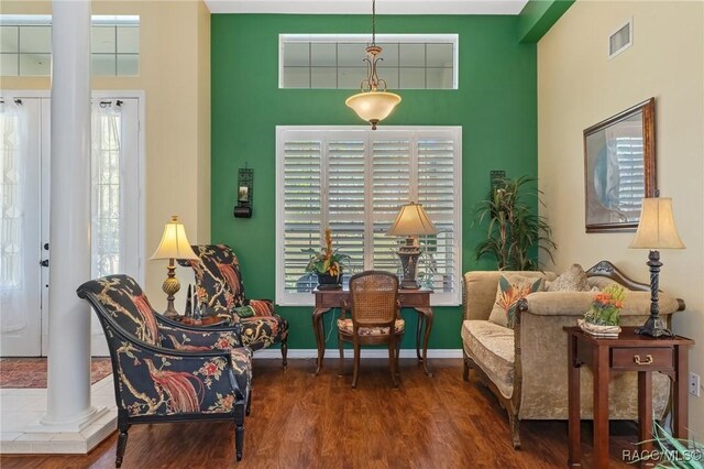 sitting room featuring visible vents, wood finished floors, decorative columns, and baseboards