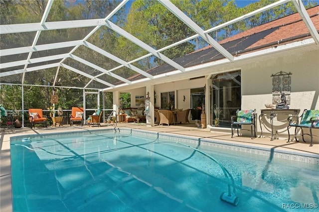 pool with a lanai, outdoor lounge area, and a patio