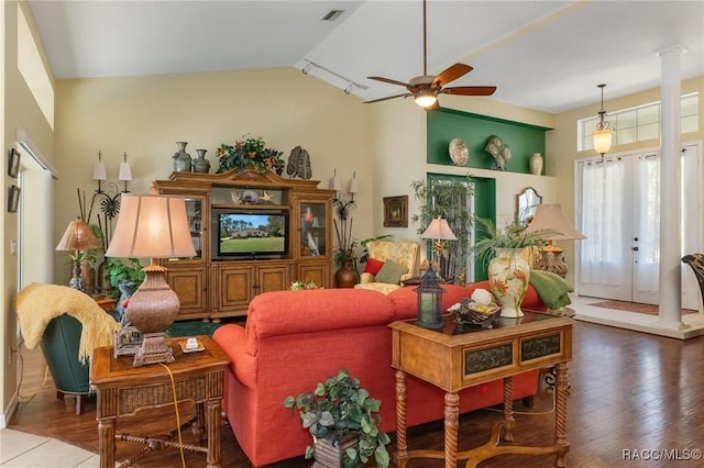 living room with lofted ceiling, visible vents, ceiling fan, wood finished floors, and ornate columns