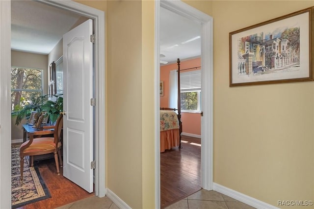 corridor featuring baseboards and tile patterned floors