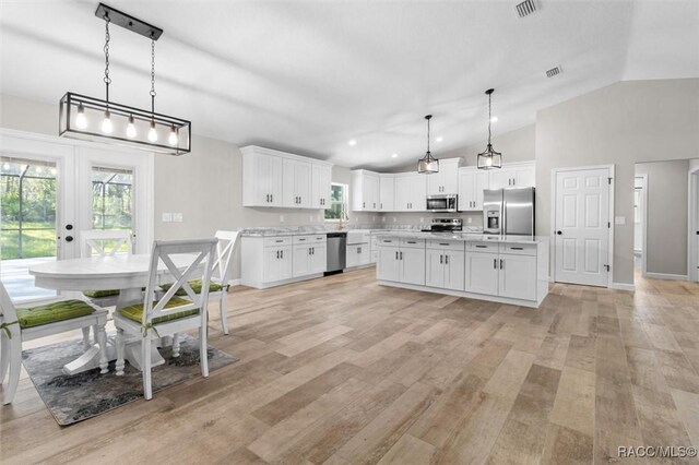 5379 N Nakoma Dr, Beverly Hills, FL 34465 - kitchen with stainless steel appliances, vaulted ceiling, french doors, light countertops, and white cabinetry