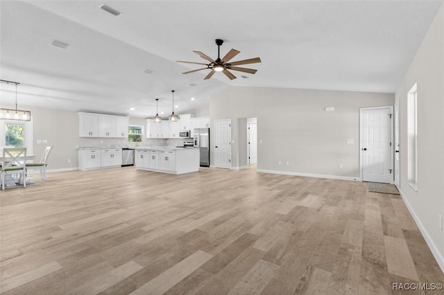 5379 N Nakoma Dr, Beverly Hills, FL 34465 - unfurnished living room with lofted ceiling, a ceiling fan, plenty of natural light, light wood finished floors, and a chandelier
