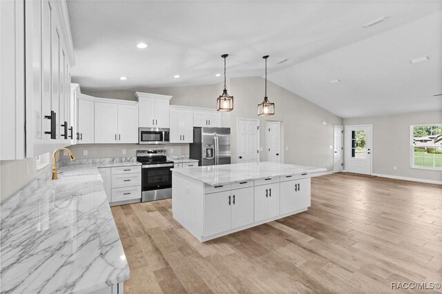 5379 N Nakoma Dr, Beverly Hills, FL 34465 - kitchen with stainless steel appliances, a kitchen island, lofted ceiling, white cabinetry, and light wood-type flooring