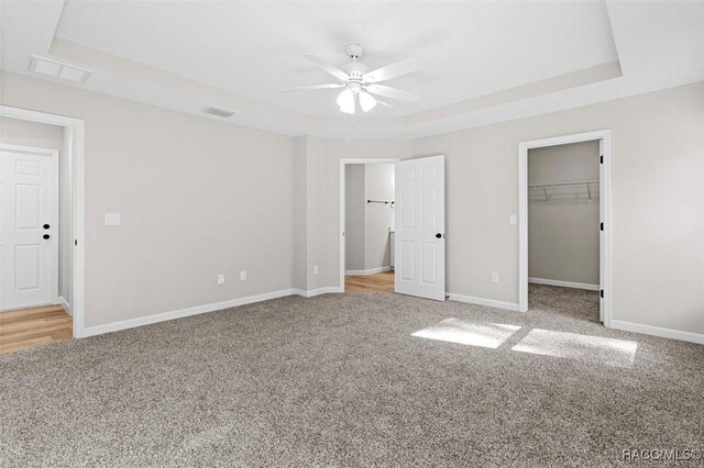 5379 N Nakoma Dr, Beverly Hills, FL 34465 - unfurnished bedroom featuring a raised ceiling, carpet, a walk in closet, a closet, and a ceiling fan