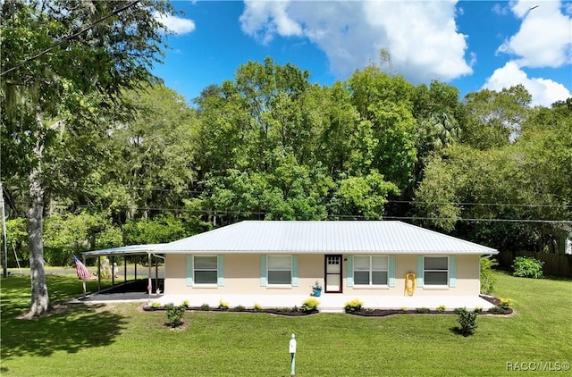 ranch-style home with a front lawn, stucco siding, an attached carport, and metal roof