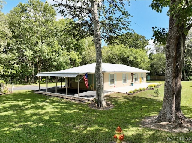 rear view of property featuring a carport and a yard