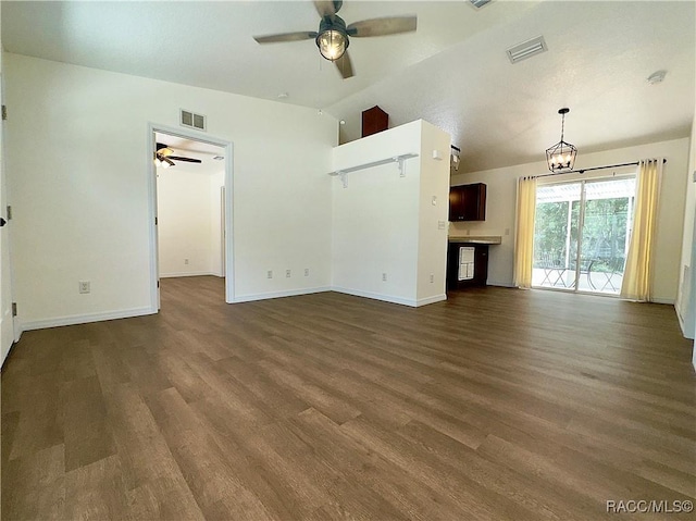 unfurnished living room with visible vents, dark wood-type flooring, ceiling fan with notable chandelier, and vaulted ceiling