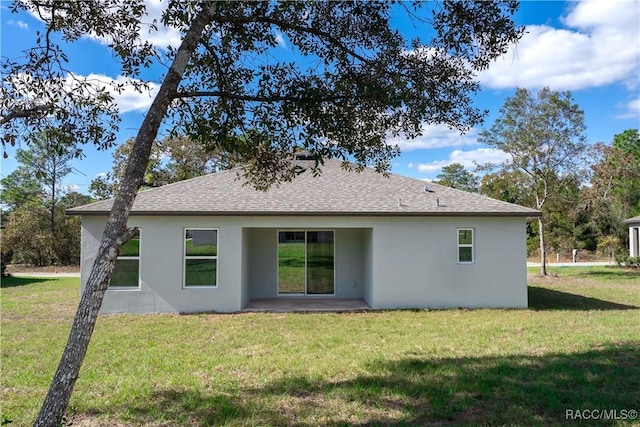 back of property with a patio area and a lawn