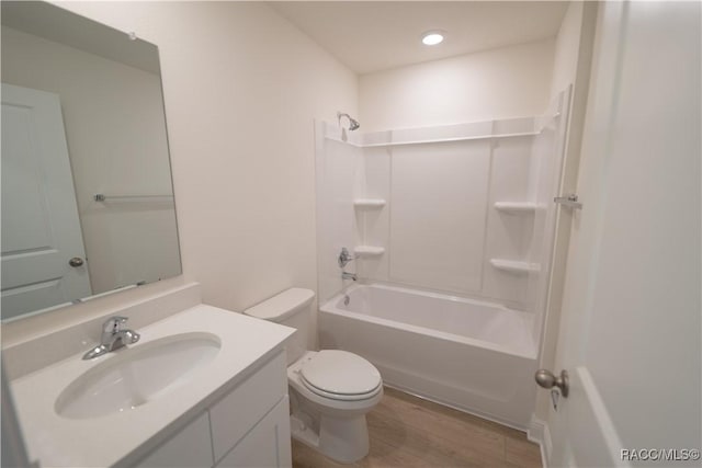 full bathroom featuring hardwood / wood-style flooring, vanity, toilet, and washtub / shower combination