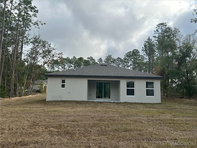 back of house with a lawn