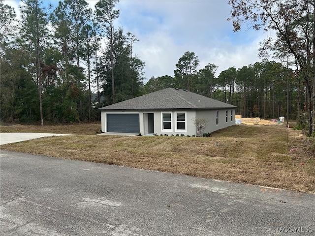 view of front of home featuring a front yard and a garage