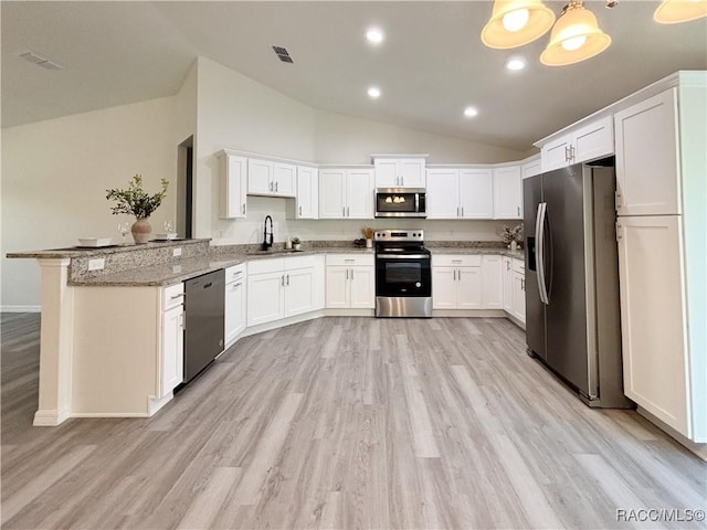 kitchen featuring a peninsula, a sink, visible vents, appliances with stainless steel finishes, and light stone countertops